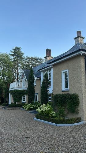 a house with a large driveway in front of it at Caney Lodge in Kilkenny