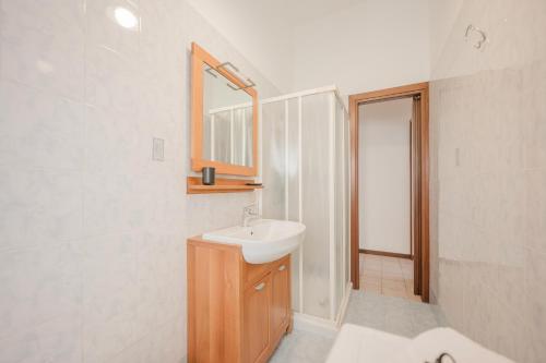 Un baño blanco con lavabo y espejo. en Ca' Brunetti - 10 minuti from Venice & Free Parking, en Venecia