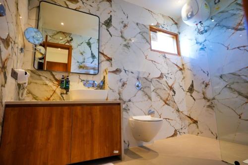 a bathroom with a marble wall with a sink and a toilet at The Elet in Amritsar