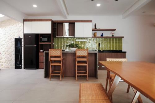 a kitchen with a wooden table and a black refrigerator at Beachside escape in Kuala Terengganu, Malaysia in Kampong Cherong Baru