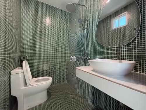 a bathroom with a toilet and a sink and a mirror at Beachside escape in Kuala Terengganu, Malaysia in Kampong Cherong Baru