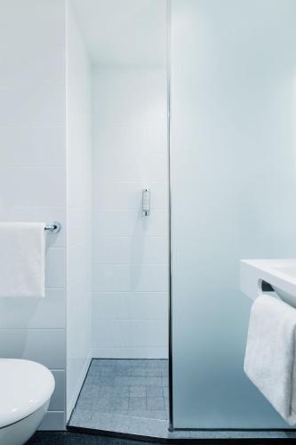 a bathroom with a shower and a toilet at B&B HOTEL Zürich Airport in Rümlang