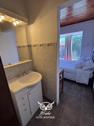 un bagno con lavandino e un letto con finestra di Búho Hotel Boutique a Formosa