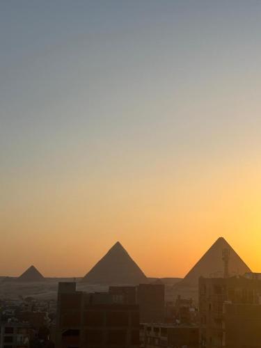 a view of the pyramids of giza at sunset at Rost pyramids view in Cairo