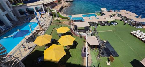 an aerial view of a resort with a tennis court and umbrellas at Jewel Sharm El Sheikh Hotel in Sharm El Sheikh