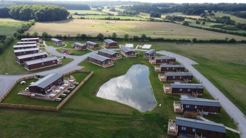 an aerial view of a resort complex with a pond at Clumber Park Lodges in Worksop