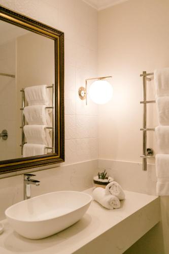 a bathroom with a large white tub and a mirror at Romantic Wine Estate Stay in The Midlands in Howick