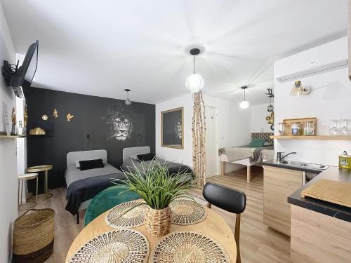 a kitchen and living room with a table in a room at O'BERCAIL in Tournon-sur-Rhône