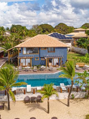 a house with a swimming pool next to a resort at Hotel Espelho D'Água Arraial e Beach Club in Arraial d'Ajuda