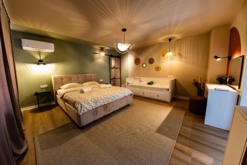 a bedroom with a bed and a tub in it at FLH - Citadel Garden - Casă cu Curte și Parcare Privată lângă Cetatea Alba Carolina - Loc de Joacă și Ciubăr in Alba Iulia