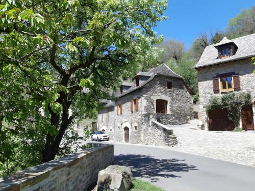 ein Steinhaus mit einem Auto in der Einfahrt in der Unterkunft Gîte dans un Village d’Exception in Belcastel