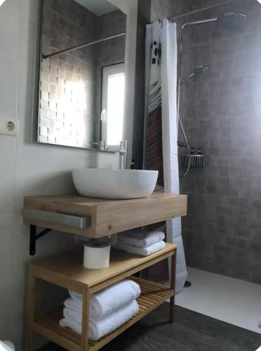 a bathroom with a counter with a sink and a shower at Cafú Casita entorno natural cerca de Betanzos in Coirós