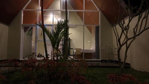 a building with a large window with a palm tree at Kaliningrat Cottage 2 in Pronojiwo