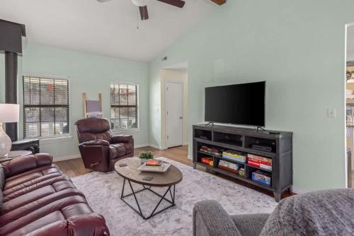 a living room with a couch and a tv at 4BR Game-Day Retreat - Foosball & Fire Pit in Fayetteville