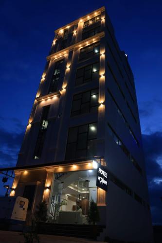 a tall building with lights on it at night at Hotel jetway in Muthugadahalli