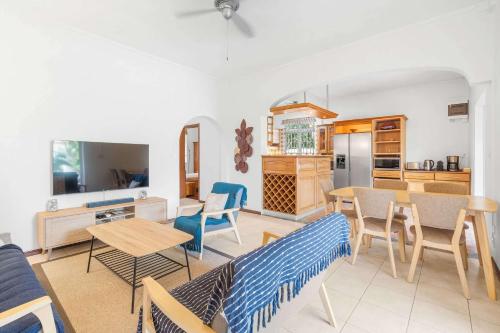a living room with a couch and a table and chairs at Serenity Bay - Perfect Tropical Stay in Pointe aux Cannoniers