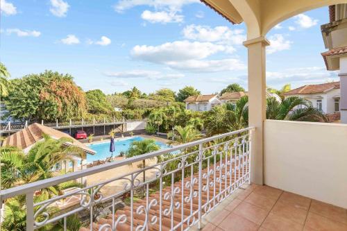 a balcony with a view of the pool at Serenity Bay - Perfect Tropical Stay in Pointe aux Cannoniers