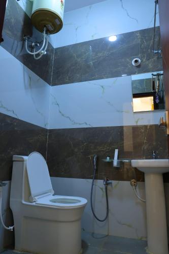 a bathroom with a toilet and a sink at Hotel jetway in Muthugadahalli