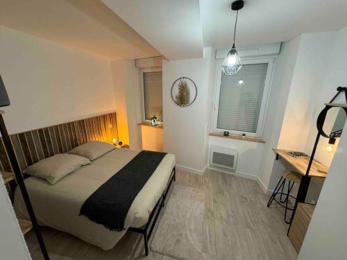 Un dormitorio con una cama y un escritorio y una ventana. en Maison Lyloni Méral, en Méral