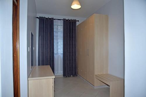 a room with a bench and a window with curtains at ENZI FURNISHED APARTMENT DIANI in Ukunda