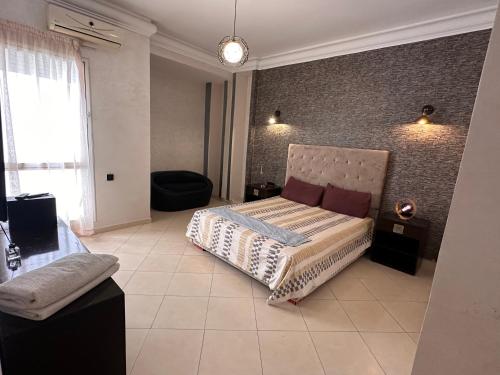 una camera da letto con un letto e un muro di mattoni di Spacious & luxurious apartment a Kenitra