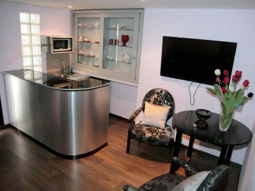 a living room with a television and a table and chairs at Hotel Tulipa in Bragança