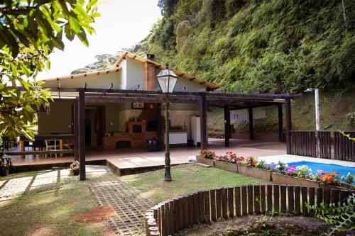 una casa con piscina delante de ella en Chale com lazer completo nas Montanhas, en Vítor Hugo
