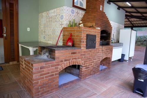 Un horno de ladrillos al aire libre en una sala de estar. en Chale com lazer completo nas Montanhas, en Vítor Hugo