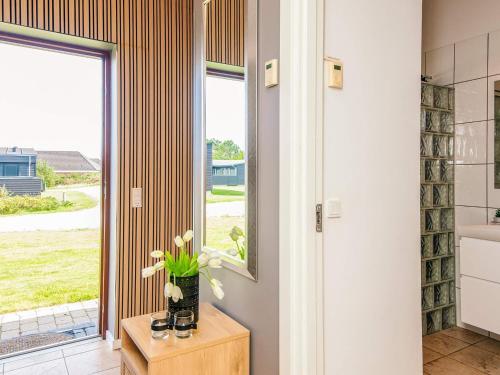 a bathroom with a window and a vase of flowers on a table at Exclusive Retreat with Spa - By Traum Ferienwohnungen in Rømø Kirkeby