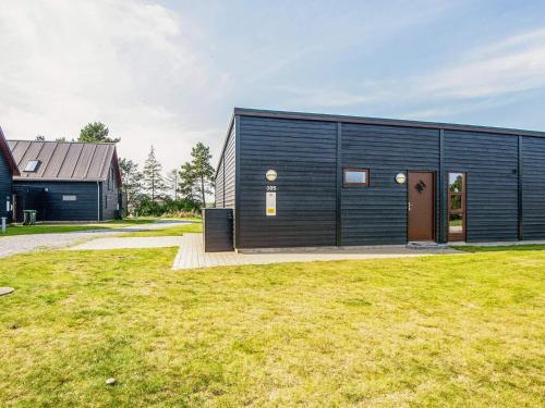 a black building with a door and a grass field at Exclusive Retreat with Spa - By Traum Ferienwohnungen in Rømø Kirkeby