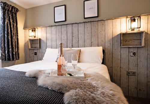a bedroom with a bed with a bottle of champagne and glasses at Chestnut Meadow Country Park in Sidley