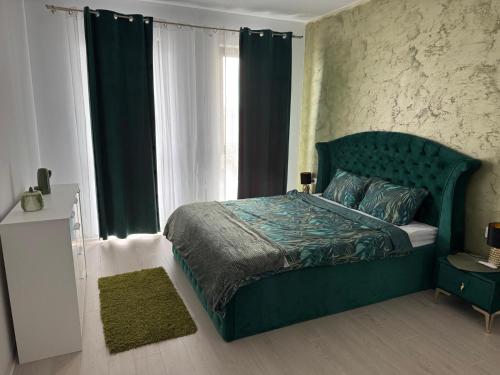 Una cama verde en un dormitorio con ventana. en RakanStudioApart, en Timisoara
