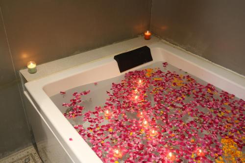 a bath tub filled with lots of pink sprinkles at Elight Inn Hotel in Jaipur