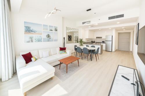 a living room with a white couch and a table at Resort lifestyle, Fantastic Views, Bright & Brand new in Dubai