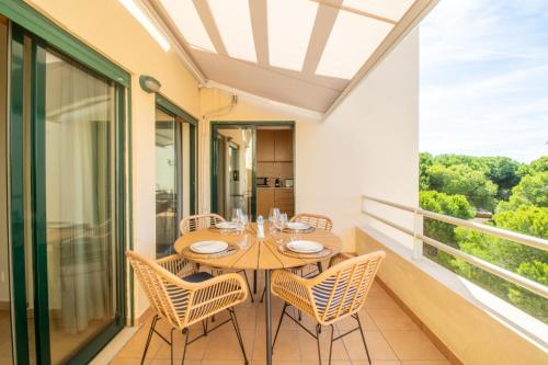 a dining room with a table and chairs on a balcony at Dunes Apartment - Near the Beach in Guia