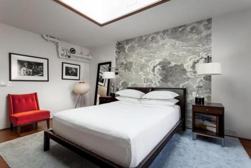 a bedroom with a large bed and a red chair at Roedonis SoHo in New York