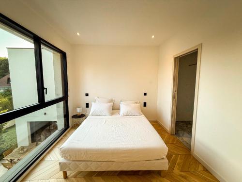 a bedroom with two beds and a large window at Les Trois Cyprès in Blois
