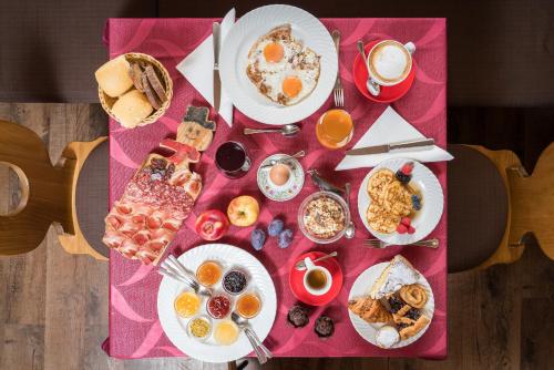 a table topped with plates of breakfast foods and coffee at Hotel La Baita in Madonna di Campiglio