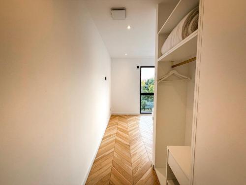 a hallway with a white wall and a window at Les Trois Cyprès in Blois
