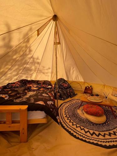 a tent with a bed and a table in it at Happy Meadows - Mushroom Street in Long Stratton