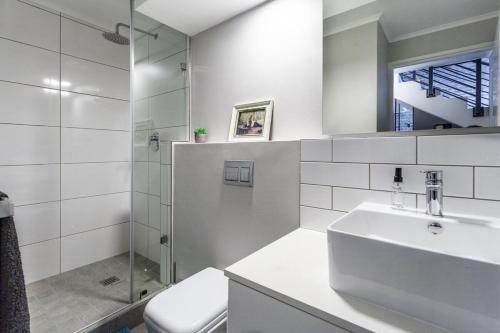 un bagno con lavandino, doccia e WC di Stylish Cape Town Penthouse a Città del Capo