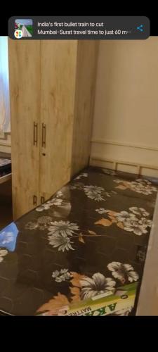 a bedroom with a bed with a floral blanket at Vyavasthapan hostels in Pune