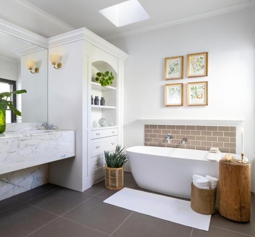 a white bathroom with a tub and a sink at Grace House in Robertson