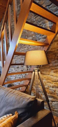 a bed and a lamp in a room with wooden ceilings at Le Chalet - Maison de vacances in La Roche-en-Ardenne