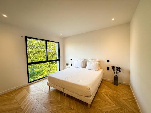 a bedroom with a large bed and a window at Les Trois Cyprès in Blois
