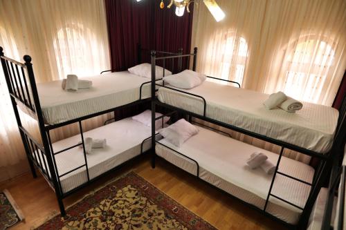 three bunk beds in a room with windows at Cappadocia Hostel in Goreme