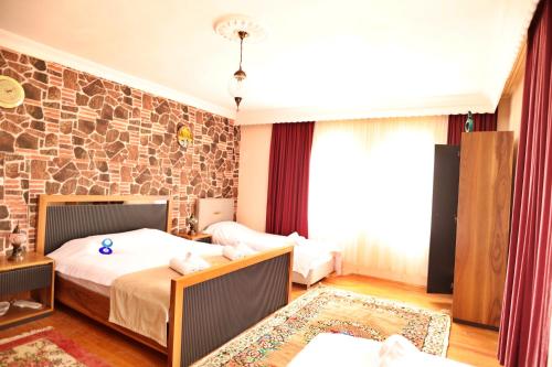 a bedroom with two beds and a stone wall at Cappadocia Hostel in Goreme
