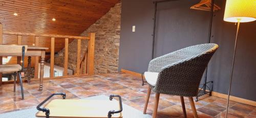 a living room with a chair and a table at Le Chalet - Maison de vacances in La Roche-en-Ardenne