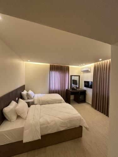 a bedroom with a large bed and a desk at Midtown Lweibdeh Hostel in Amman