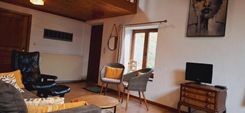 a living room with a couch and chairs and a tv at Le Chalet - Maison de vacances in La Roche-en-Ardenne